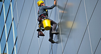 Image of Man cleaning the windows of a high-rise building