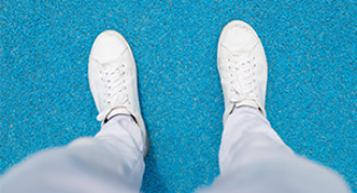 Image of Person's feet, wearing white shoes